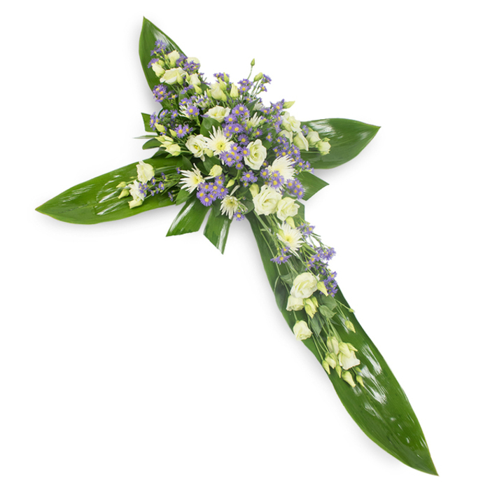This refined floral cross, photographed against a stark white background from a slightly elevated viewpoint, is a study in textural contrast and quiet reverence. The foundation is a lattice of large, glossy tropical leaves - think Ti or similar - their dark green planes and visible veins shaping the arms and centre of the Christian cross with a polished, natural firmness. Arranged with horticultural care, the blooms concentrate around the midline and flow outward along each arm: soft, cream-tinged lisianthus with layered petals and poised buds create the main volume, while clusters of compact white chrysanthemums or small spray roses brighten the composition with rounded form and clarity. Interspersed throughout are sprays of small, star-shaped lavender or pale purple flowers, likely limonium or asters, which introduce a delicate lift of cool colour and create visual depth among the creamy whites. Narrow, feathery green filler softens edges and blends blossom into leaf, allowing the cross to read both as a floral artwork and a solemn emblem. The lighting is even and gentle, accentuating the leaves' sheen and the flowers' soft surfaces, and the overall impression is one of calm dignity. Locally, this is the kind of sympathy piece a Norbiton florist would prepare for church services or crematorium tributes, assembled with steady hands and delivered with quiet care across Kingston, Norbiton Station area and nearby residential streets.