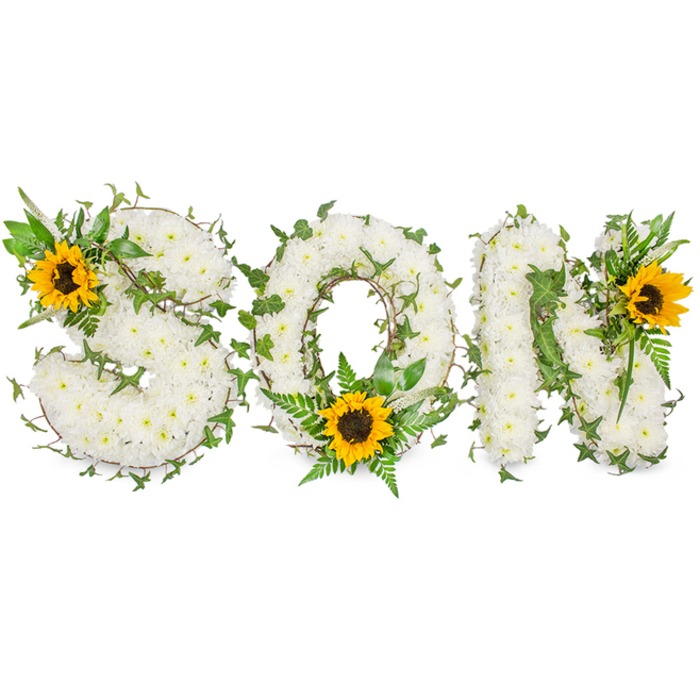 A striking, three-dimensional sympathy tribute carefully shaped to spell SON in capital letters, each letter densely covered in small, immaculate white chrysanthemums that form a soft, tactile surface resembling snowy petals packed in close. Interlaced throughout the white floral base are rich, dark-green ivy vines whose sinuous stems and distinct lobed leaves snake around the contours of each letter, adding sculptural depth and a timeless, evergreen quality. Complementing these tones are lighter green fern fronds and pointed foliage that breathe space into the design and highlight the curvature of each form. Three bold sunflowers provide focal points: a radiant bloom sits in the upper-left curve of the S, another nestles at the bottom centre of the O amid the fern fronds, and the third adorns the upper-right shoulder of the N - each sunflower's golden-yellow petals radiate outward from a deeply textured dark-brown centre, drawing the eye across the composition. The arrangement is photographed against a stark white backdrop with balanced, soft lighting that accentuates shadow, petal texture, and the contrast between white, deep green, and warm yellow. As a crafted funeral tribute, this piece conveys a layered message - serenity through white chrysanthemums, continuity in the green foliage, and comforting brightness from the sunflowers - suitable for families in Norbiton, Kingston town centre, or those holding services near Norbiton Station or the local crematorium.