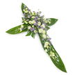 A solemn, hand-crafted floral cross laid against a plain white backdrop, seen from a slight overhead angle so each detail reads clearly. The structural arms and central point are formed from broad, glossy tropical leaves with visible veins, their deep green sheen providing a bold, protective foundation like a pair of sheltering wings. At the heart of the cross and running softly along the arms sits a dense, carefully clustered mass of blooms in a tranquil palette of soft white, creamy ivory and pale lavender. Ruffled lisianthus with layered petals and gentle closed buds provide the principal white masses, their satin textures and subtle cream undertones catching the light; between them sit small, rounded white chrysanthemums or spray roses that add bright punctuation and a comforting, familiar form. Threaded through and lifting the composition are sprays of tiny, star-like lavender or light purple accents, suggestive of limonium or aster, which give depth and a whisper of cool colour against the warm whites. Fine green fillers are tucked into the floral groups, their delicate fronds softening the transitions from blossom to leaf. The arrangement reads quiet and reverent, scented faintly of green foliage and freshly cut blooms rather than heavy perfume, and is crafted to convey peace, respect and remembrance at funerals or memorial services. As a local florist would note, its clarity, textural contrast and calm tones make it a dignified tribute for faith-based ceremonies across Norbiton and neighbouring Kingston, delivered with care and sensitivity when families seek a gentle expression of condolence.